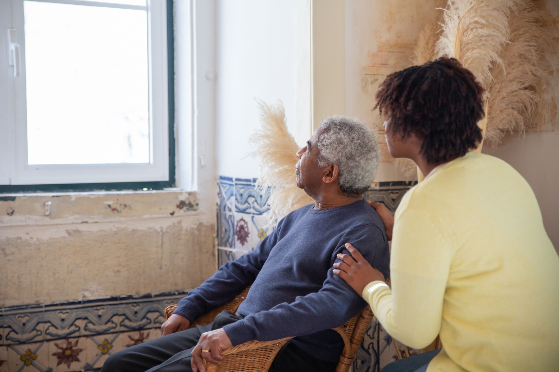 An older person receiving calm support from a younger caregiver